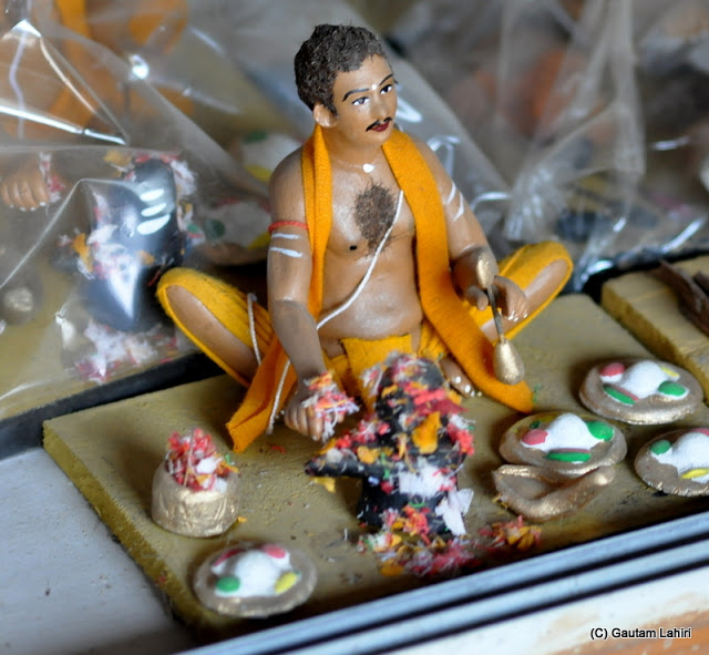 Here we see a man worshiping the Shiva deity, holding the bell in his left hand as he looks on, even the resting pot belly is seen delicately created  at Krishnanagar, West Bengal, India by Gautam Lahiri