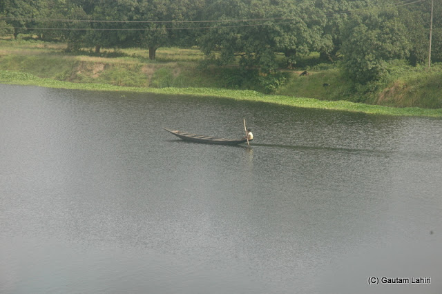 A boatman cuts through the Jalangi river for passengers to ferry them across at Krishnanagar, West Bengal, India by Gautam Lahiri
