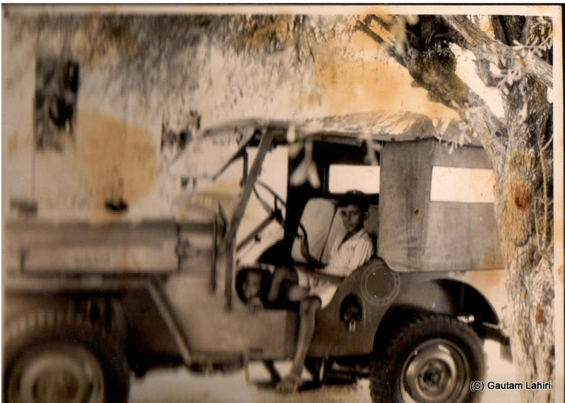 The Jeep CJ-3B parked under a shade of a tree before she started her eventful journey. My sister about three years old takes a peek from the Jeep at my father who shot this picture at Kishngarh, Rajasthan, India by Gautam Lahiri