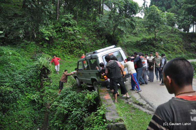After the arm steadied the Sumo, local people from the near by village helped the Sumo to safety. Look at the road edge which is keeping the Sumo from disappearing into the ditch up front at Mangan, Sikkim by gautam lahiri