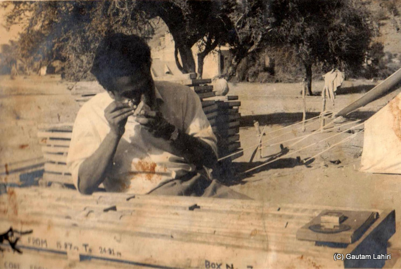 My father, examines intently, rock and cartographic samples at Degana, Rajasthan, India beside a tent by Gautam Lahiri