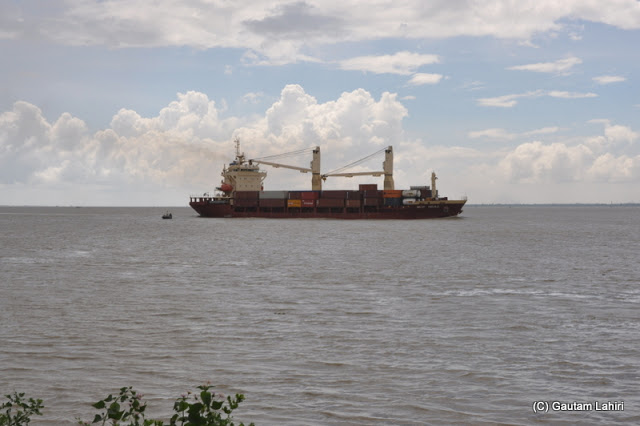 Huge commercial ocean liners pierce the massive, and broad Ganges river flowing past Diamond Harbor, West Bengal, India by Gautam Lahiri