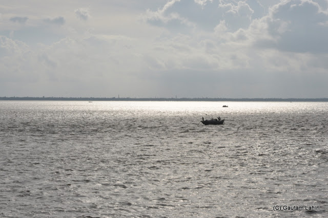 Setting sun on Hooghly ..a boat makes its way under the cover of the cloud at Diamond Harbor, West Bengal, India by Gautam Lahiri