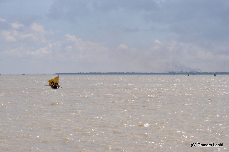 A small fishing boat sets off from the banks of river Ganges at Diamond Harbor, West Bengal, India by Gautam Lahiri