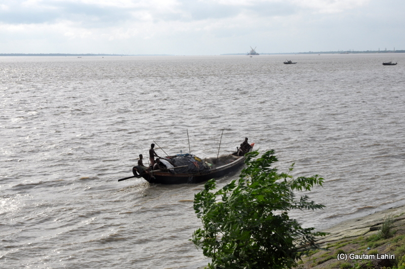 A boat spears away through the Hooghly water as the late afternoon wind drives everything away at Diamond Harbor, West Bengal, India by Gautam Lahiri
