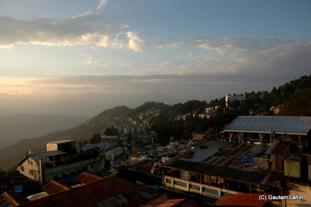 Along the hill edge as we walked, the town with its small and conical houses draped the hill surface ..all under the glare of the morning sun  at Darjeeling, West Bengal, India by Gautam Lahiri