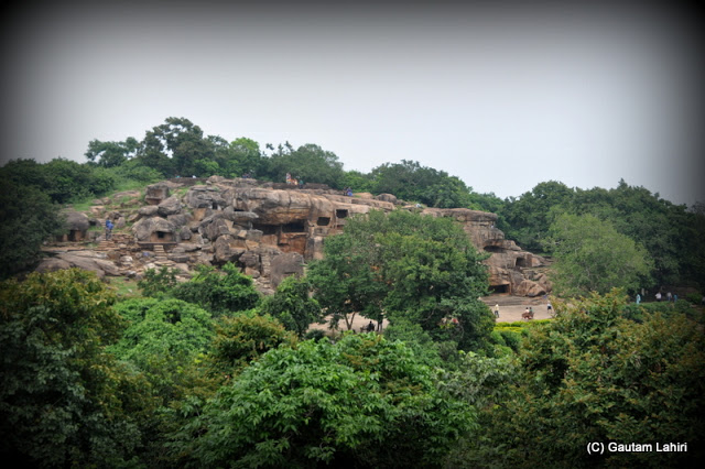 We were seeing the Udayagiri rock caves from Khandagiri hill, entombed in its rocky layers amidst trees  at Bhubaneshwar, Odissa, India by Gautam Lahiri