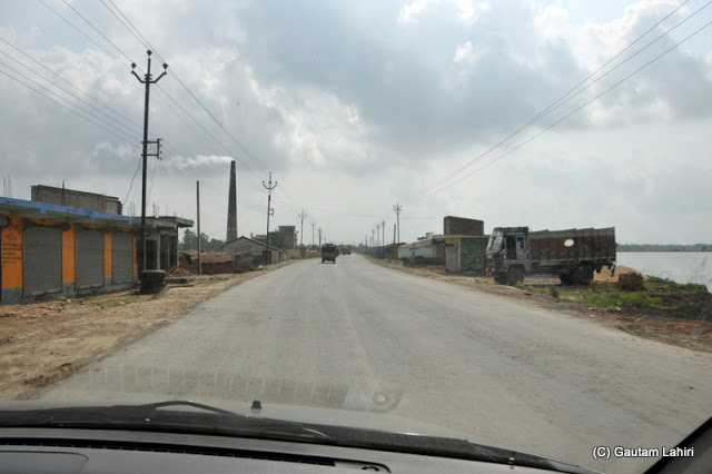 Water reservoirs and brick-kilns flanked the road and we were able to pick up speed as the road was both good and empty due to midday sun blazing away at Taki, West Bengal, India by Gautam Lahiri