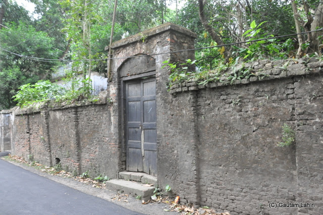 A huge derelict wooden door in another wall of the Rajbari on the main Taki road at Taki, West Bengal, India by Gautam Lahiri