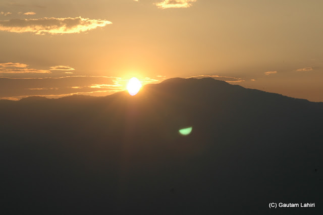 The sun skirts the hill edge as it climbs the golden sky over the Tiger Hill  at Darjeeling, West Bengal, India by Gautam Lahiri