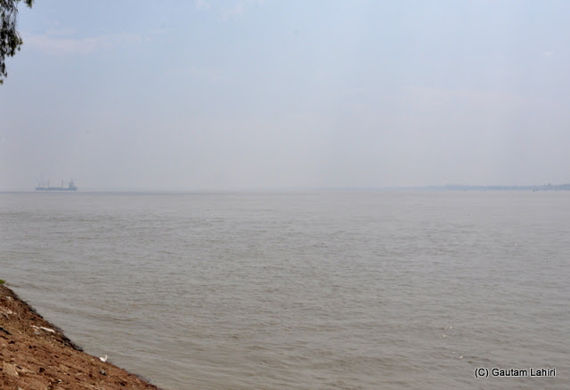 The river went on for miles into the horizon and all we saw was a moving ship in the morning haze at Gadiara, Hooghly, West Bengal, India by Gautam Lahiri