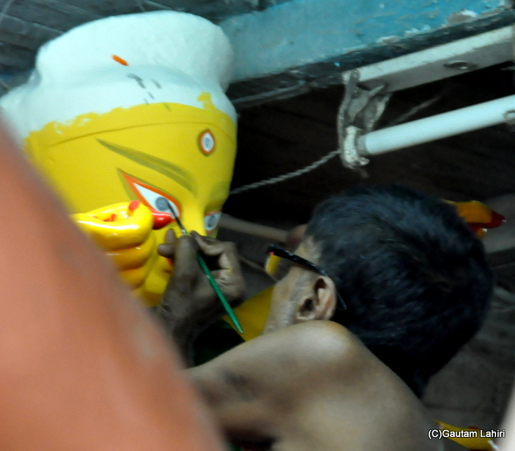 The potter draws the eyes of a Durga idol at kumartoli, north Kolkata by gautam lahiri