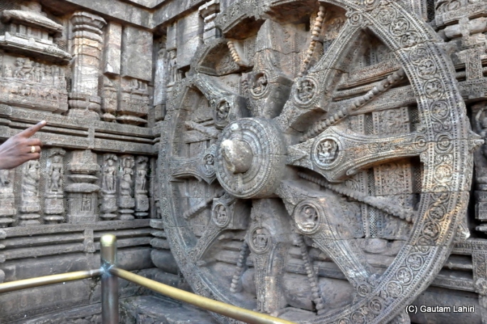 One of the twenty four wheels that adorn the temple base, the interval between each spoke is three hours and each beaded rod is ninety minutes apart and by placing the index finger on the wheel hub, and looking at the falling shadow, the bead which gets the shadow tells the time of the day  at Puri, Odisha, India by Gautam Lahiri
