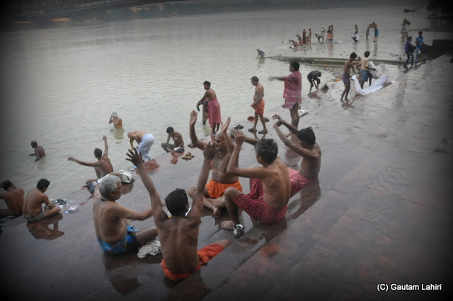Men chanting hymns on the watery steps leading to the river at Kolkata, West Bengal, India by Gautam Lahiri
