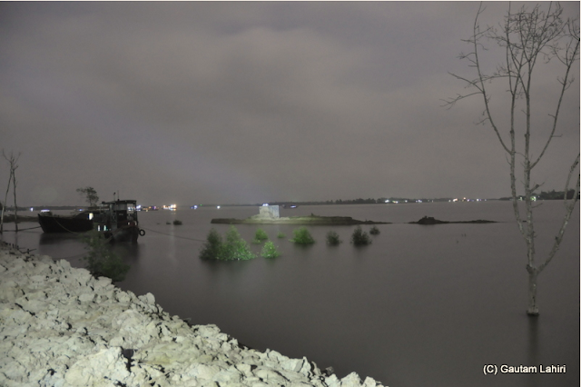 Along the path, the river edge disappears into the distance, all you see is foreboding forest far away under a cloudy sky  at Sunderbans National Park, West Bengal, India by Gautam Lahiri