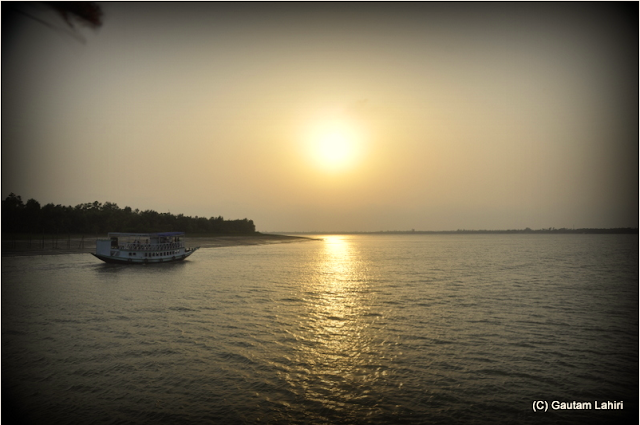The setting sun and the house boat raced to reach the western horizon  at Sunderbans National Park, West Bengal, India by Gautam Lahiri