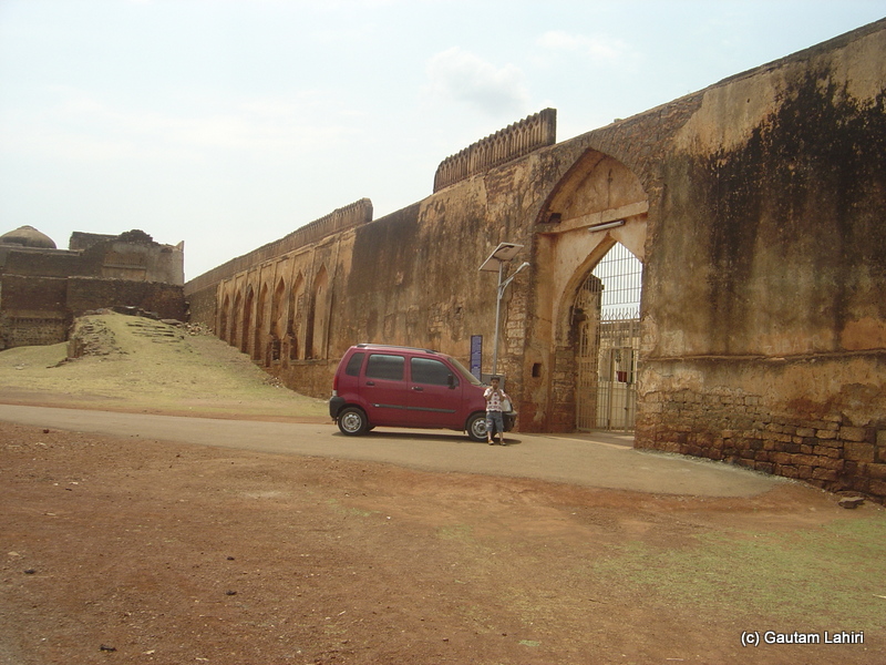 We were parked in front of the Gagan Mahal. Instead of the leashed and restless horses, stood the red Wagon R. The arched gateway gave way to an opening that was well maintained with a green bush that complemented the blue sky above at Bidar fort by Gautam Lahiri