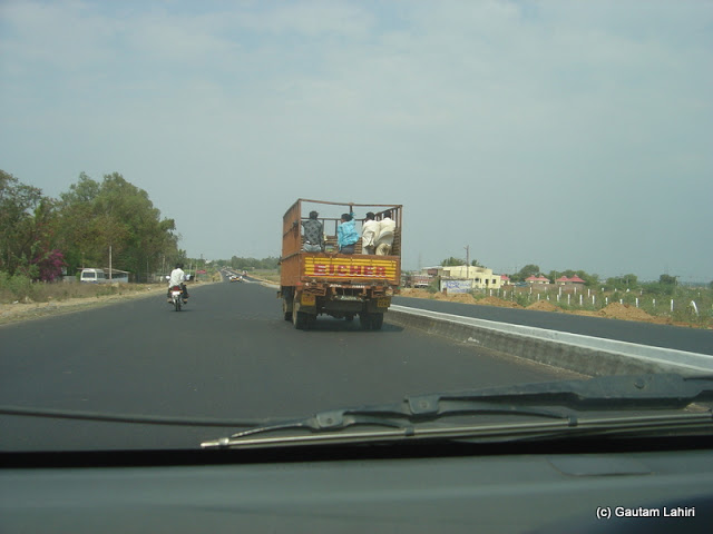 A lone truck with its light load drove through a typical country side of Hyderabad to Bidar. Low two storied houses dotted the skyline on either sides of the road by Gautam Lahiri