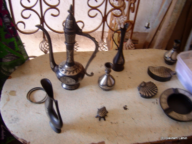 Bidriware objects lay displayed in front of us - Water decanter, ashtray, plaques, and there stood the wine decanter in Bidar by Gautam Lahiri