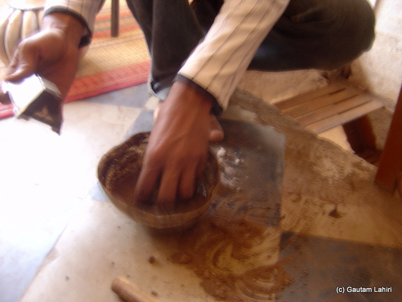 Kaseem applying the soil with a mix of water in it. The object on his left-hand gets its touch and started to lighten up the mundane room with its ageless glow at Bidar by Gautam Lahiri