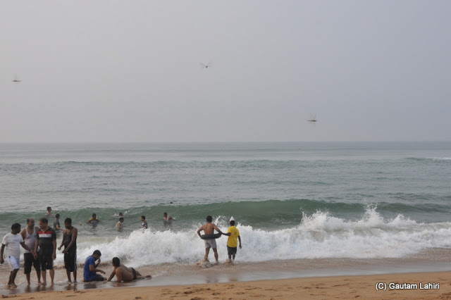 Waves splash, people float on rubber tubes and the day brightens making all of us stay in the water forever  at Puri, Bhubaneshwar, Odisha, India by Gautam Lahiri